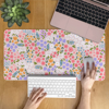 Cute Floral Desk Mat featuring small colourful flowers on a pink background, perfect to personalise your space and add a layer of comfort.