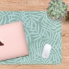 Botanical desk mat with soft green background and delicate leaf pattern