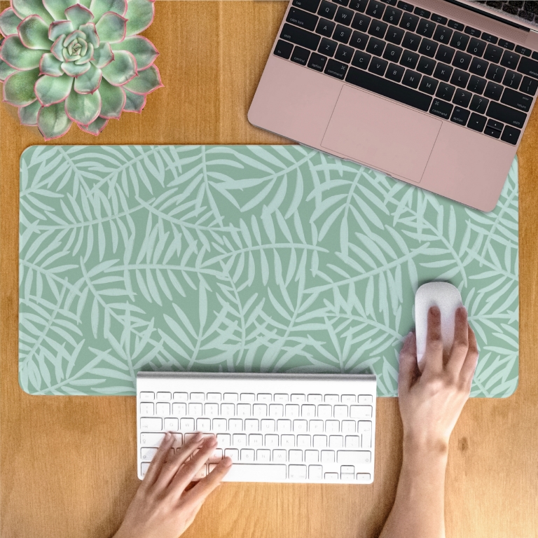 Minimalistic green leaves desk mat on a wood desk, designed by Dessi Designs